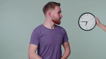 Confused man with anxiety checking time on clock, running late to work, being in delay, deadline video