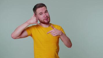 vrolijk een Mens in t-shirt op zoek Bij camera aan het doen telefoon gebaar Leuk vinden zegt Hallo u telefoontje me terug video