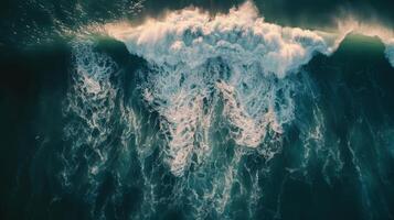 Spectacular aerial top view background photo of ocean sea water white wave splashing in the deep sea.