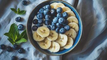 a breakfast bowl with blueberries and bananas, a breakfast bowl with blueberries and bananas. photo