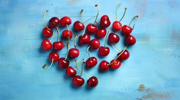 Heart shape made from ripe cherry fruits on a blue background. photo