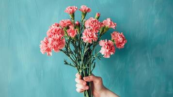 Bouquet of pink carnation flowers over blue background. Saint valentine, mothers day idea photo