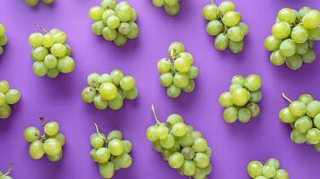 Fresh juicy grapes on a vibrant purple background, arranged in a top view flat lay style display. photo
