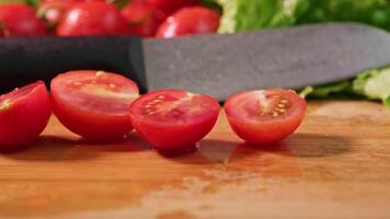 red tomatoes on a branch. water drops. close-up.Leaves of lettuce. knife video