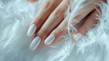glamour mujer mano con lujo blanco color uña polaco manicura en dedos, conmovedor blanco plumas, cerca arriba foto