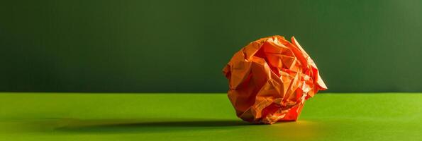 A crumpled piece of paper sits on a green table photo