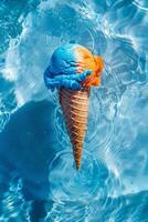 vibrante azul y naranja hielo crema cono sumergido en agua foto