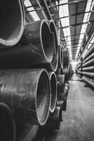 Series of Large Metal Pipes Stacked in Industrial Warehouse photo