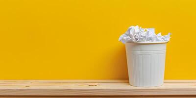 Overflowing White Trash Bin Against a Bright Yellow Background photo