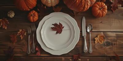 A table with a white plate and silverware with a leaf on it photo