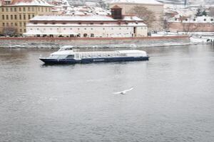 nieve en praga, raro frío invierno condiciones. Praga barco en checo república, Nevado clima con edificios foto