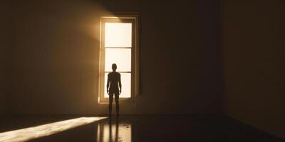 Silhouette of a Person Standing Before a Bright Window in an Empty Room photo