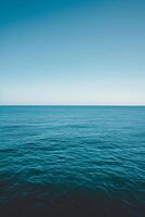 The ocean is calm and blue, with no waves or ripples photo