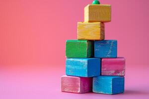 Stack of Colorful Wooden Blocks in a Haphazard Arrangement on Pink Background photo