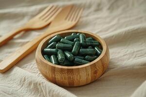 Round Wooden Bowl Filled with Green Vitamin Capsules photo