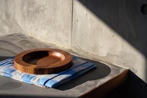 A wooden bowl sits on a blue and white towel on a counter photo