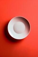 A white plate is sitting on a red background photo