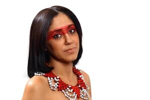 sonriente morena modelo en brasileño indio disfraz y maquillaje participación un tapioca, un típico brasileño bocadillo foto