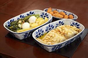 oven-baked cod with potatoes, eggs, broccoli, garlic and cod fritters on a platter photo