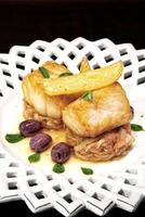 baked cod with onions, french fries and olives photo