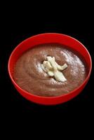 chocolate mousse in red plastic bowl with cocoa fruit slices photo