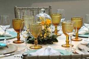 sophisticated lunch table setup in yacht club with plates, glasses, flowers and cutlery photo