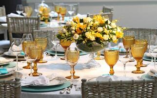 sophisticated lunch table setup in yacht club with plates, glasses, flowers and cutlery photo