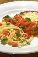 Filetto parmigiano with spaghetti in tomato and basil sauce photo