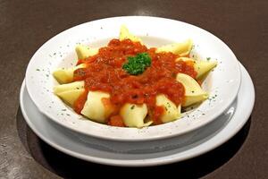 cheese conchiglione with tomato sauce on plate photo