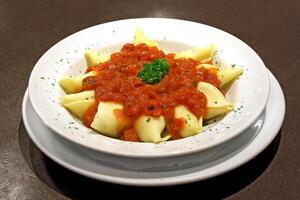 queso conchiglione con tomate salsa en plato foto