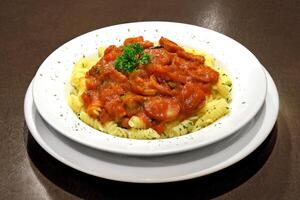 pasta with tomato sauce and pepperoni sausage on plate photo