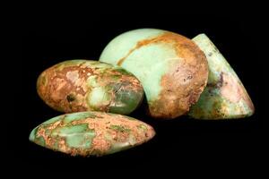 cut and rough precious stones on a black background photo