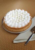 Lemon pie with whipped cream on the table photo
