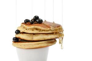 pancakes with blueberry and honey on white background photo