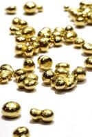small gold nuggets on white background photo