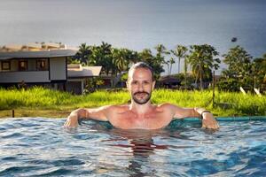 young man enjoying vacation at the beach and pool photo