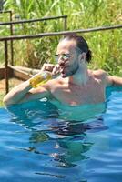 young man enjoying vacation at the beach and pool photo