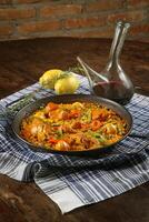 Paella Valenciana with seafood, rabbit meat, chicken, rice and saffron photo