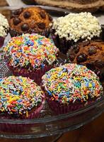 delicious chocolate muffins in tray on wooden table photo