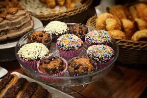 delicious chocolate muffins in tray on wooden table photo