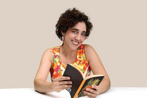 young woman reading and writing at her desk photo