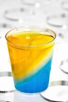 colored gelatin in plastic cups in a transparent acrylic display photo