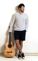 young model with mustache posing with his guitar on neutral background photo