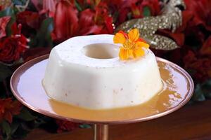 Coconut Flan with orange sauce on the platter photo