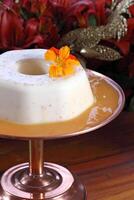 Coconut Flan with orange sauce on the platter photo