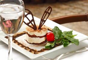 Tiramisu, clásico italiano postre con crema, galletas y chocolate polvo foto