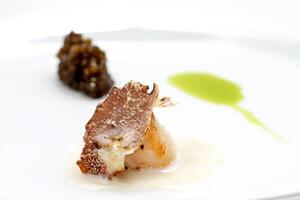 pescado con rebanada de bianco tartufo y aceituna petróleo foto