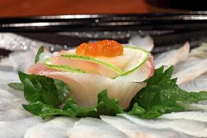 Ussuzukuri, thin cuts of white fish immersed in ponzu sauce and sriracha pepper. photo