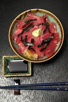 Tekka donburi, Japanese dish with rice topped with marinated tuna sashimi, soy sauce, mirim and chives photo