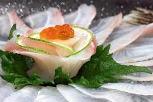 Ussuzukuri, thin cuts of white fish immersed in ponzu sauce and sriracha pepper. photo